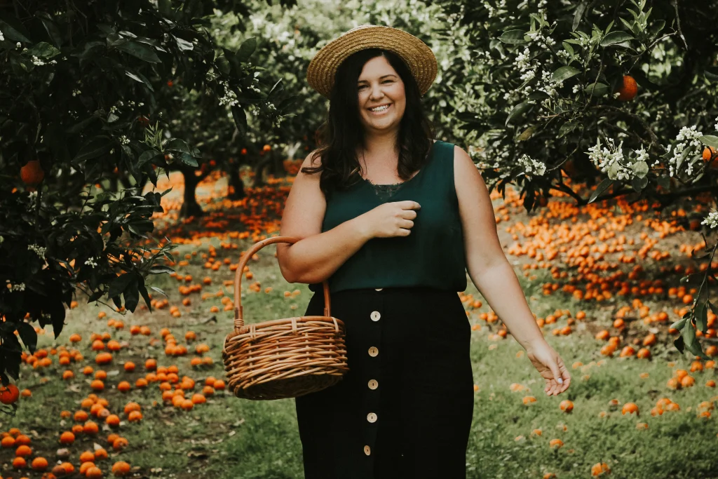 woman holding a basket of oranges